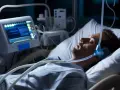 Mężczyzna śpi w łóżku szpitalnym z maską CPAP na twarzy, podłączony do aparatury monitorującej. To badanie polisomnografia.