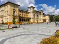 Plac przed sanatorium, gdzie obowiązują nowe zasady wyjazdu do sanatorium na NFZ. Ludzie spacerują po nowoczesnym deptaku.