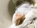 Pacjentka leży w aparacie do **scyntygrafii serca**. Badanie ma na celu ocenę pracy jej serca.