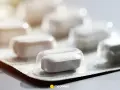 Białe tabletki w blistrze, jedna z nich wyraźna, z napisem skudexa 75 mg + 25 mg.