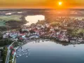 Malownicze miasteczko nad jeziorem o zachodzie słońca. Idealne miejsce na wykorzystanie bonu turystycznego i odpoczynek.
