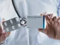 Lekarz prezentuje opakowanie leku Hydroxychloroquine 200mg i blister z tabletkami.