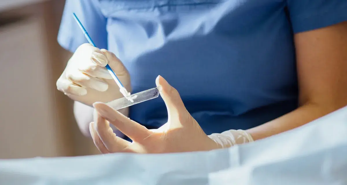 Ręce w rękawiczkach przygotowują próbkę do badania. To kluczowy etap, by dowiedzieć się, cytologia co to i jak działa.