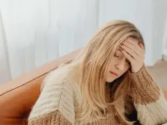 Kobieta z bólem głowy, zastanawia się, czy na umowie zlecenie jest L4.