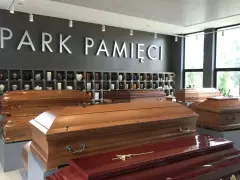 W salonie pogrzebowym "Park Pamięci" wyeksponowano trumny. W tle widać półki z urnami. To miejsce, gdzie można załatwić formalności związane z zasiłkiem pogrzebowym.
