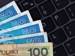 Złotówki na klawiaturze sugerują rozliczenia online, być może związane z podatkiem od darowizny.