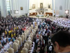 Tłum wiernych w kościele podczas uroczystości 3 maja. Wiele osób w białych szatach, prawdopodobnie duchownych, uczestniczy w nabożeństwie.