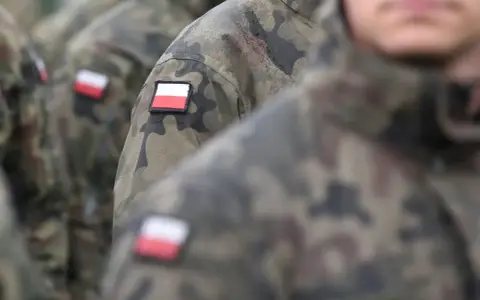 Żołnierze w mundurach moro z polskimi flagami na ramionach, gotowi do służby lub po latach zasłużonej emerytury wojskowej.