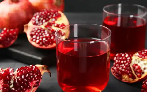 Szklanki z rubinowym sokiem z granatu i świeże owoce. Odkryj sok z granatu właściwości i ciesz się jego smakiem.