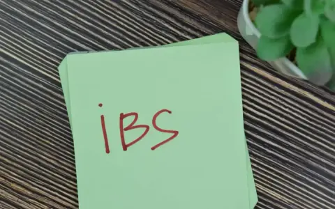 Na zielonej kartce napisano "IBS". Może to przypomnienie o lekach, takich jak Duspatalin, które pomagają w łagodzeniu objawów zespołu jelita drażliwego.