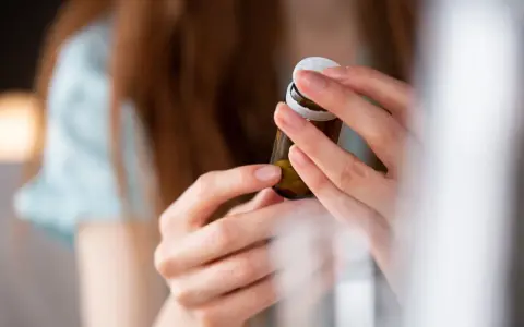 Dłonie otwierają buteleczkę z tabletkami, być może dulsevia 30, by zacząć nowy dzień.