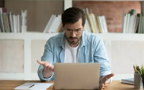 Zdezorientowany mężczyzna szuka w internecie, skąd wziąć wniosek o świadczenie wspierające.