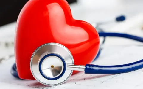 Czerwone serce i stetoskop na tle EKG. Symbolizuje troskę o zdrowie i prawidłowy poziom troponiny.