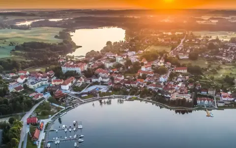Malownicze miasteczko nad jeziorem o zachodzie słońca. Idealne miejsce na wykorzystanie bonu turystycznego i odpoczynek.