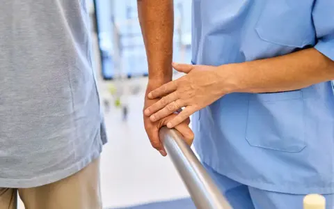Fizjoterapeuta pomaga pacjentowi w rehabilitacji. Dowiedz się, ile wynosi zasiłek rehabilitacyjny.