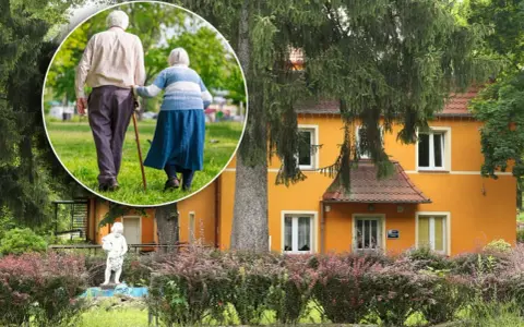 Spacer po parku przy sanatorium w Przerzeczynie Zdroju. Starsza para, wspierając się laską, cieszy się spokojnym popołudniem.