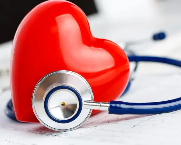 Czerwone serce i stetoskop na tle EKG. Symbolizuje troskę o zdrowie i prawidłowy poziom troponiny.