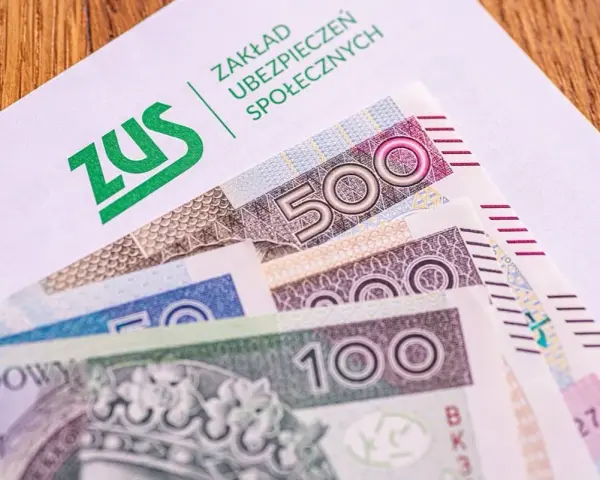 Koperta ZUS z banknotami 100 i 500 zł. Nadzieja na dodatkowe środki, jak trzynasta emerytura, dla seniorów.