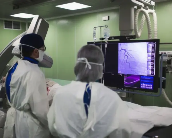 Lekarze analizują obraz z koronarografii na monitorze w sali operacyjnej.