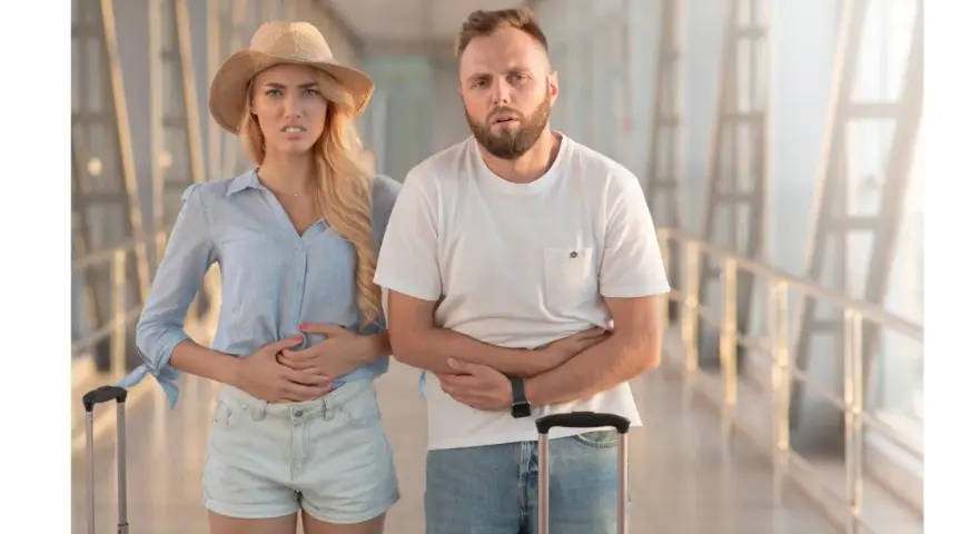 Para podróżnych z walizkami cierpi na biegunkę. Potrzebne tabletki na biegunke.