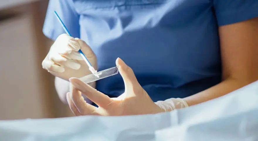 Ręce w rękawiczkach przygotowują próbkę do badania. To kluczowy etap, by dowiedzieć się, cytologia co to i jak działa.