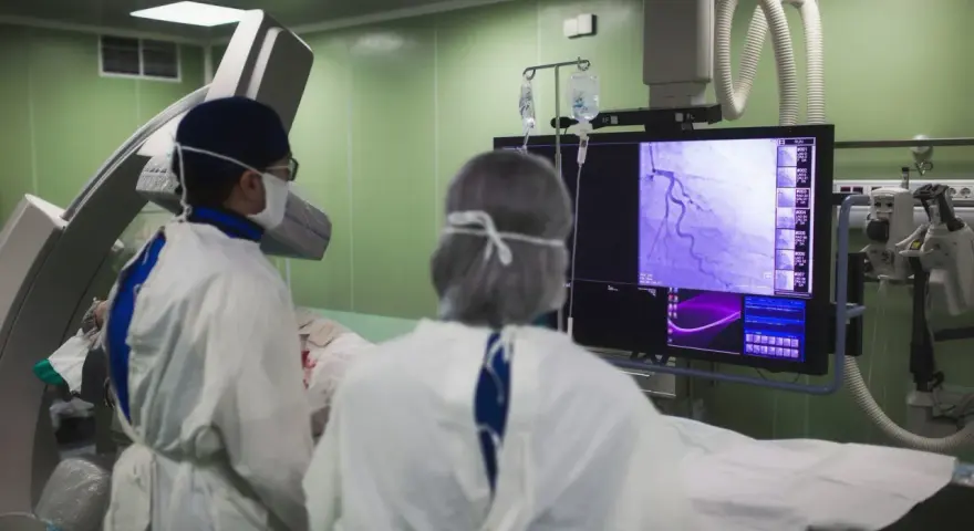 Lekarze analizują obraz z koronarografii na monitorze w sali operacyjnej.