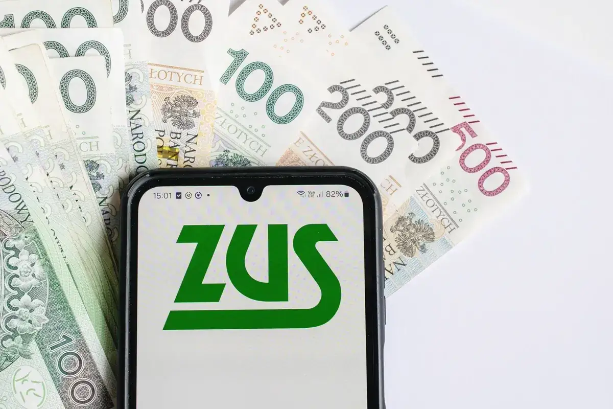 ZUS na ekranie telefonu na tle polskich banknotów. Czy to zapowiedź renty alkoholowej?