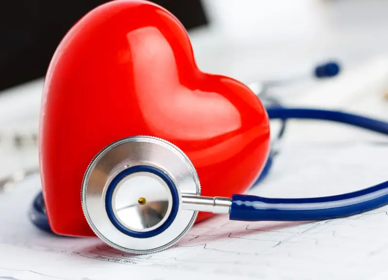 Czerwone serce i stetoskop na tle EKG. Symbolizuje troskę o zdrowie i prawidłowy poziom troponiny.